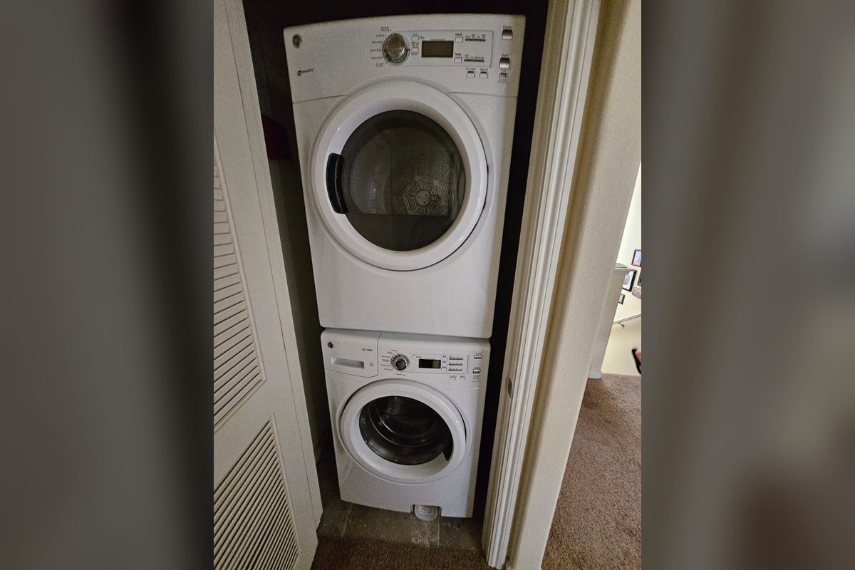 Stacked GE washer and dryer in a laundry closet serviced by Appliance Repair Indio, CA